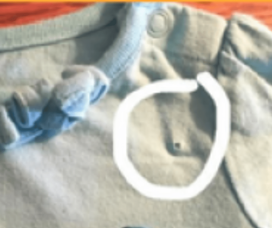 Gray polo shirt with tagging gun puncturing through garment tag at neckline.