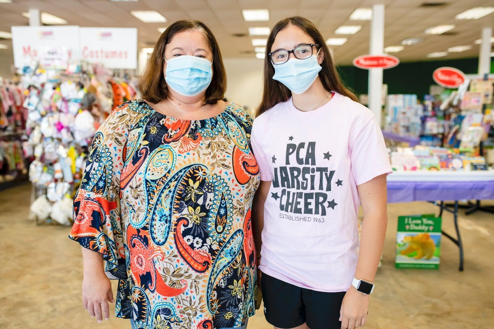 A mother and daughter stand side by side in their face masks as they shop for their kids and grandkids.